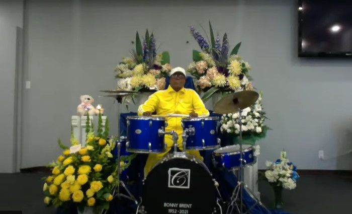 Deceased musician sits behind the drum kit